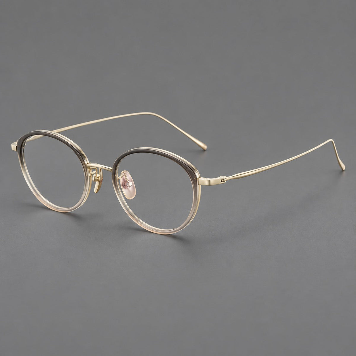Round eyeglasses in acetate and titanium with a slim curved bridge and fine metal temples in Gray Tea Gradient / Gold, three quarter view