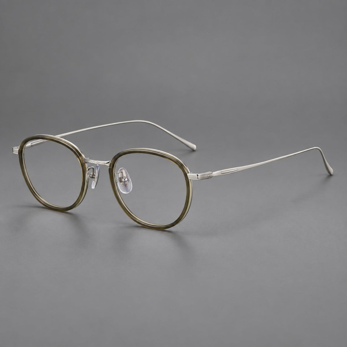 Vintage round eyeglasses in acetate and titanium with an engraved bridge and slender temples in Tea Green / Matte Silver, three quarter view