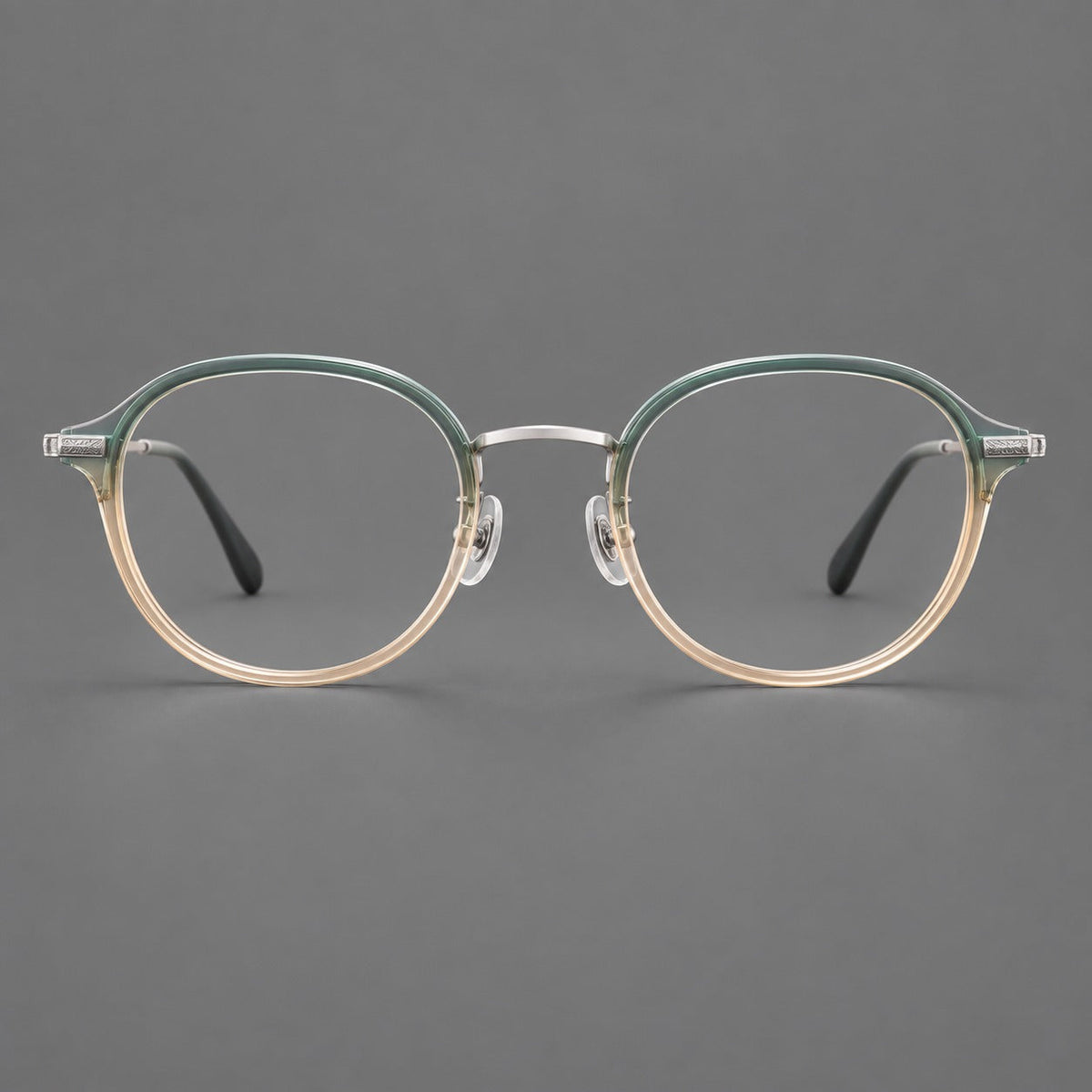 Softly rounded eyeglasses in acetate and titanium with a curved bridge and engraved temples in Green Tea Gradient / Silver, front view