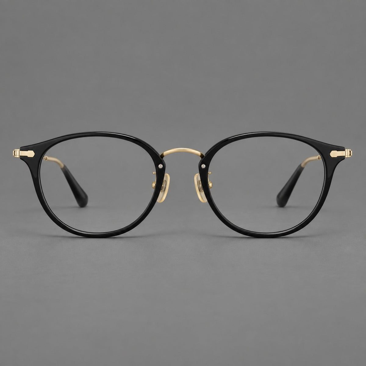 Vintage panto eyeglasses in acetate and titanium with raised brows and textured metal temples in Glossy Black / Gold, front view