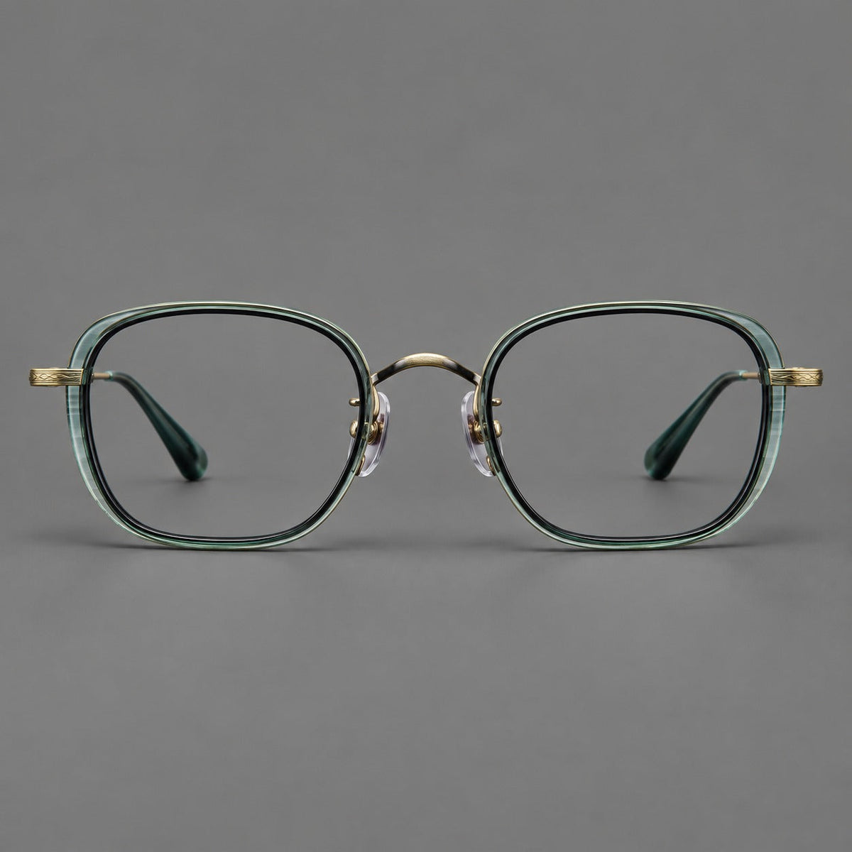 Rounded square eyeglasses in acetate and titanium with an arched bridge and engraved temples in Misted Clear Green / Antique Gold, front view
