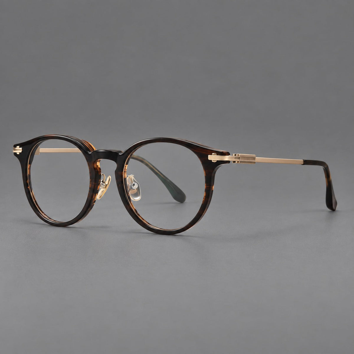 Retro acetate and titanium eyeglasses with round rims and a pronounced keyhole bridge in Brown Woodgrain / Gold, three quarter view