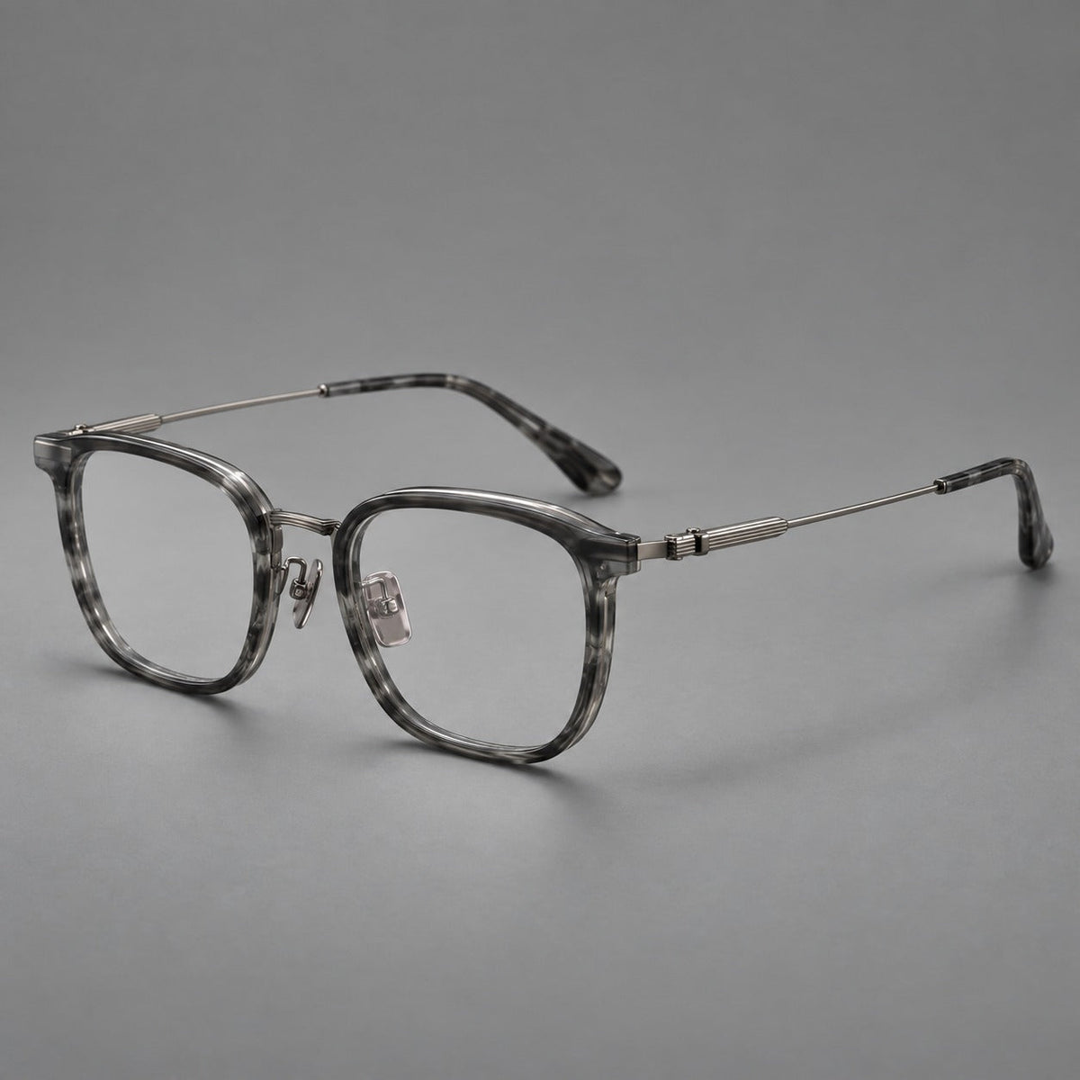 Soft square eyeglasses in acetate and titanium with wide upper corners and fine metal temples in Marbled Gray / Gunmetal, three quarter view