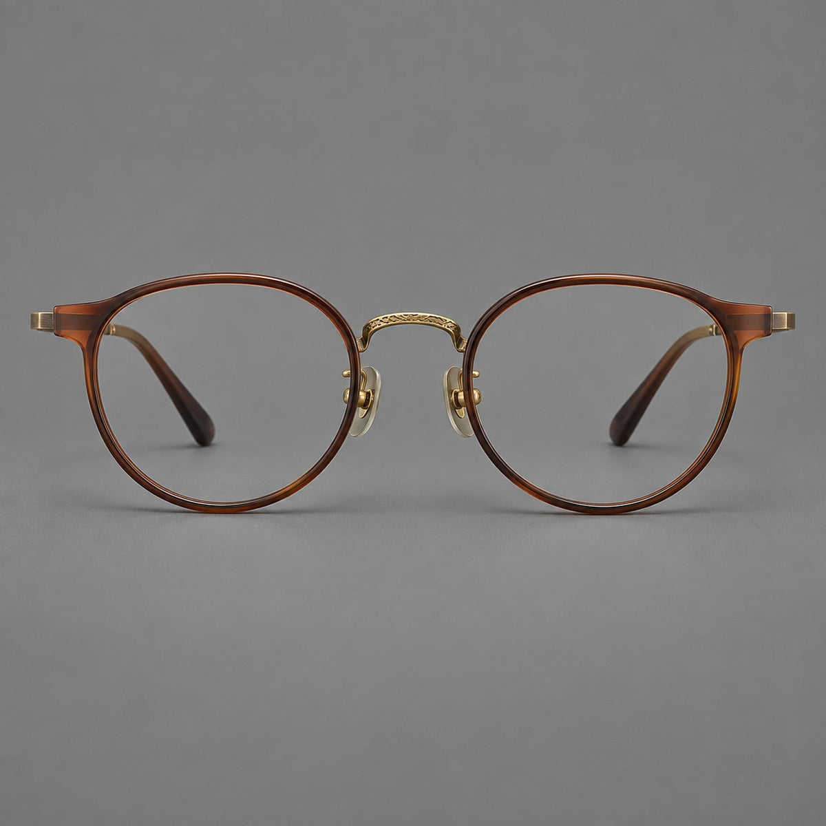 Round eyeglasses in acetate and titanium with widened outer corners and slender metal temples in Coffee Brown / Antique Bronze, front view