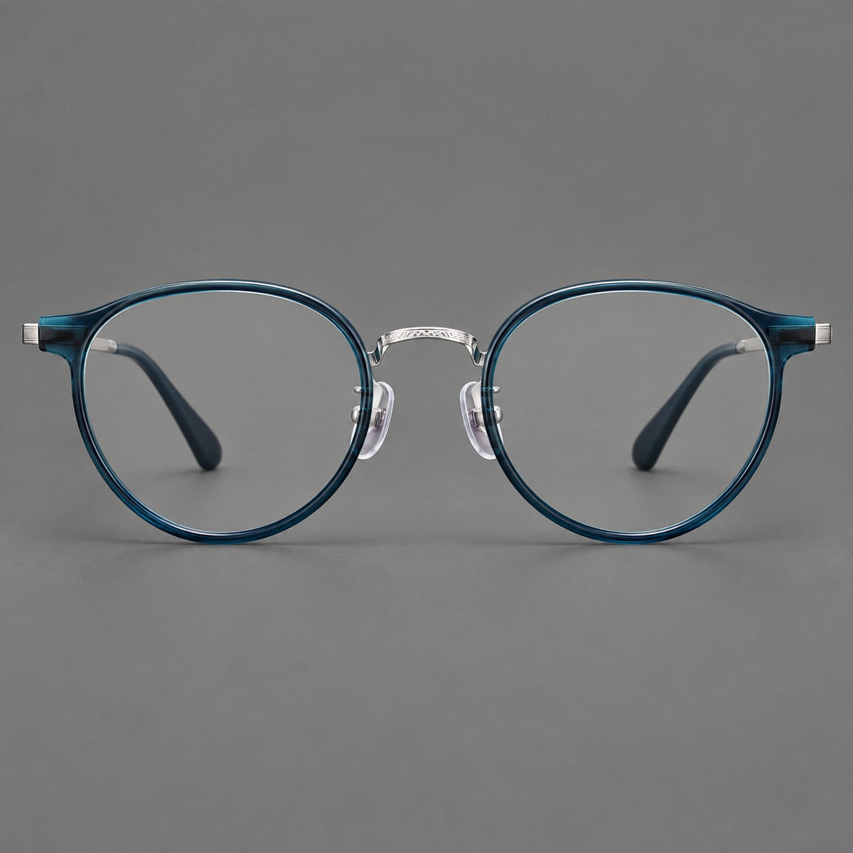 Round eyeglasses in acetate and titanium with widened outer corners and slender metal temples in Peacock Blue / Silver, front view