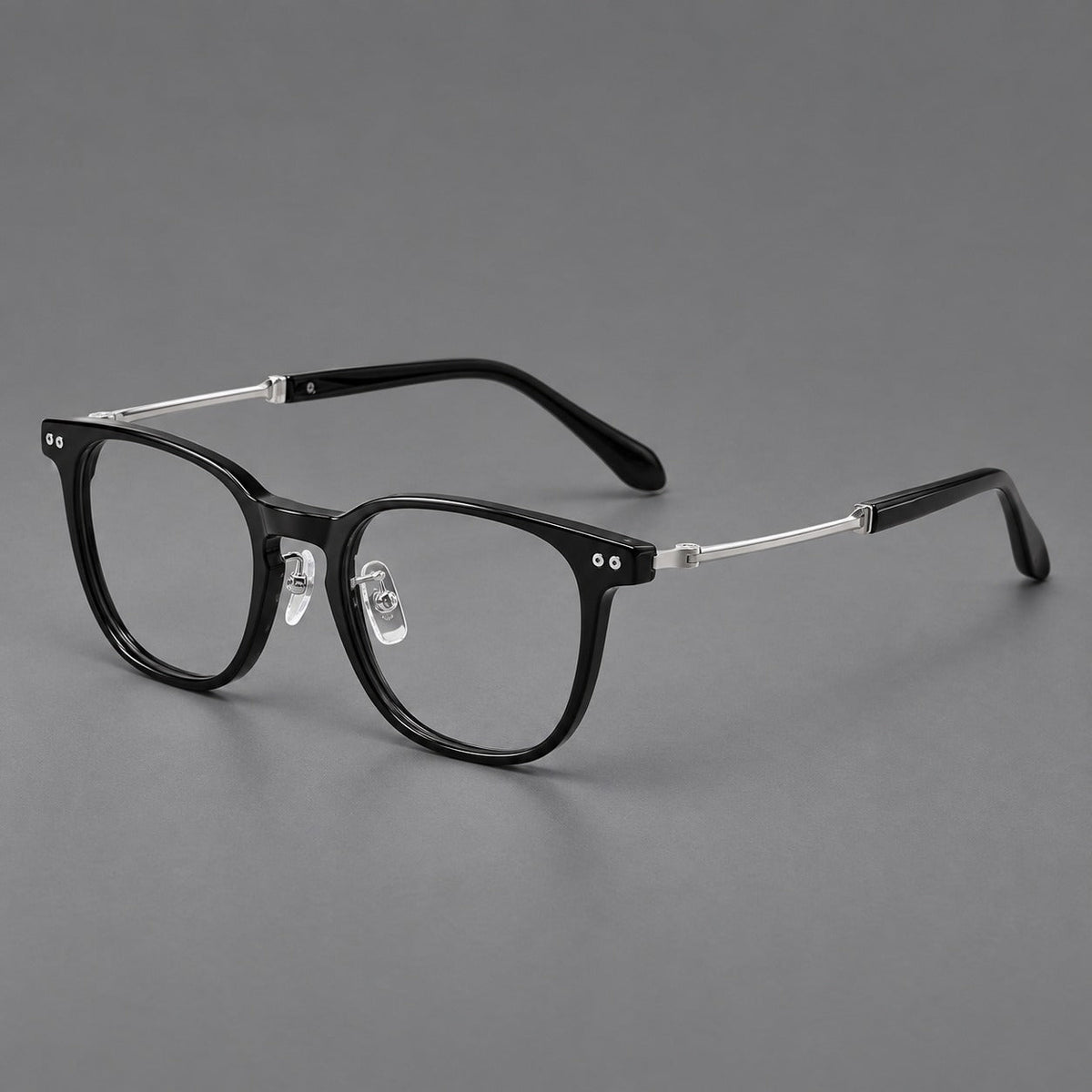 Vintage acetate and titanium eyeglasses with soft square rims and paired metal rivets in Black / Silver, three quarter view
