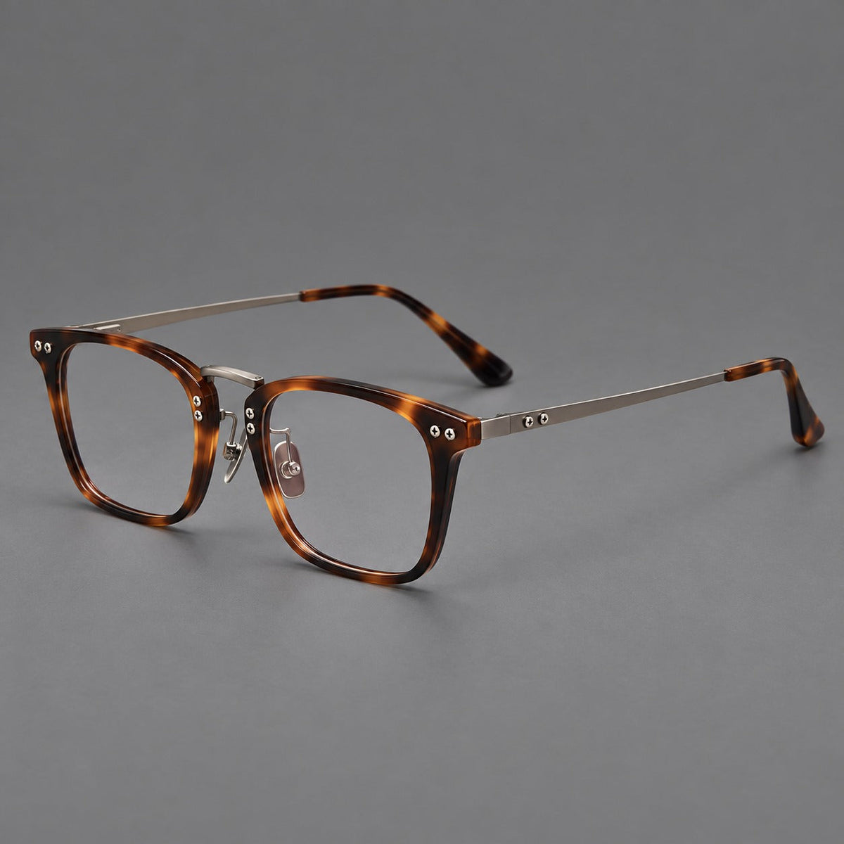 Acetate and titanium eyeglasses with angular rectangular rims and a curved metal bridge in Tortoiseshell / Gunmetal, three quarter view