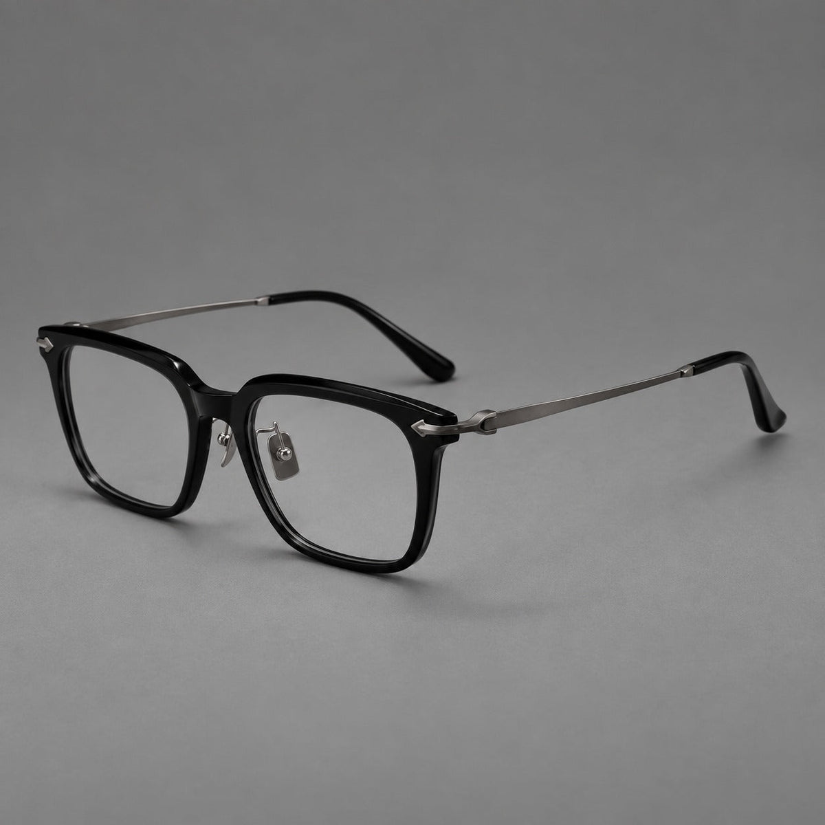 Bold acetate and titanium eyeglasses with rectangular rims and sculpted arrow accents in Black / Gunmetal, three quarter view