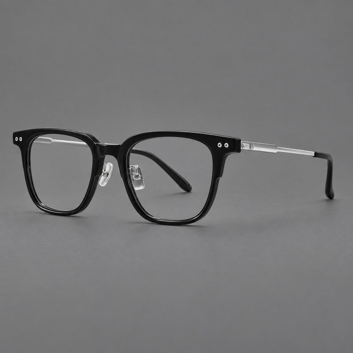 Classic acetate and titanium eyeglasses with squared brows and paired corner rivets in Black / Silver, three quarter view