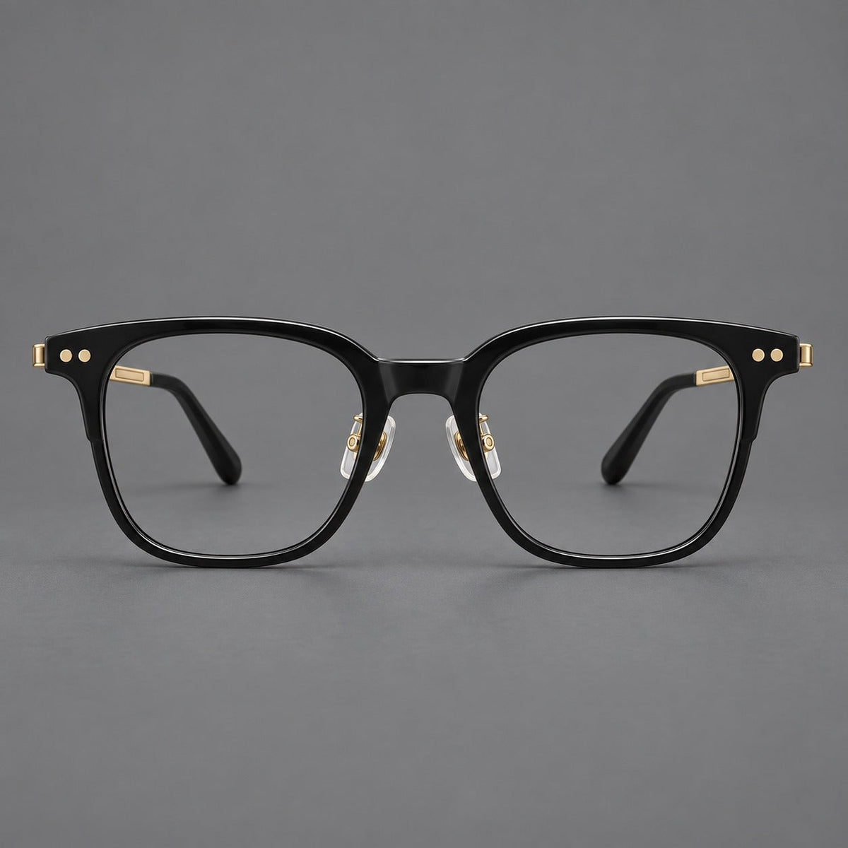 Classic acetate and titanium eyeglasses with squared brows and paired corner rivets in Black / Gold, front view