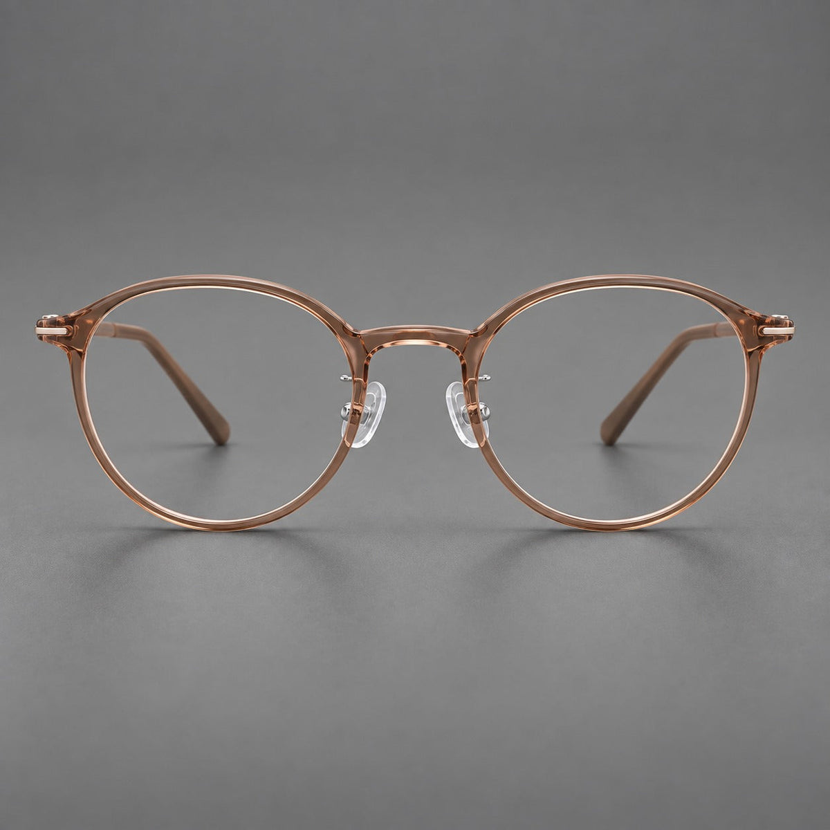 Compact round plastic eyeglasses with gently lifted corners and clear nose pads in Amber Tea, front view