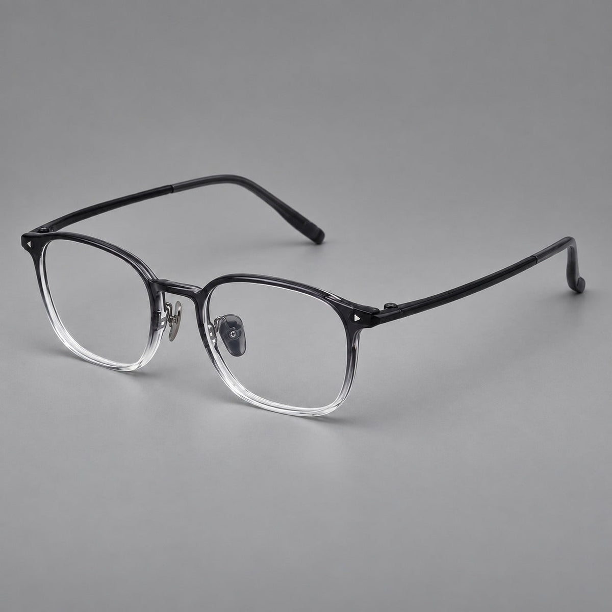 Retro square plastic eyeglasses with a curved bridge and triangular corner details in Ink Gray Gradient, three quarter view