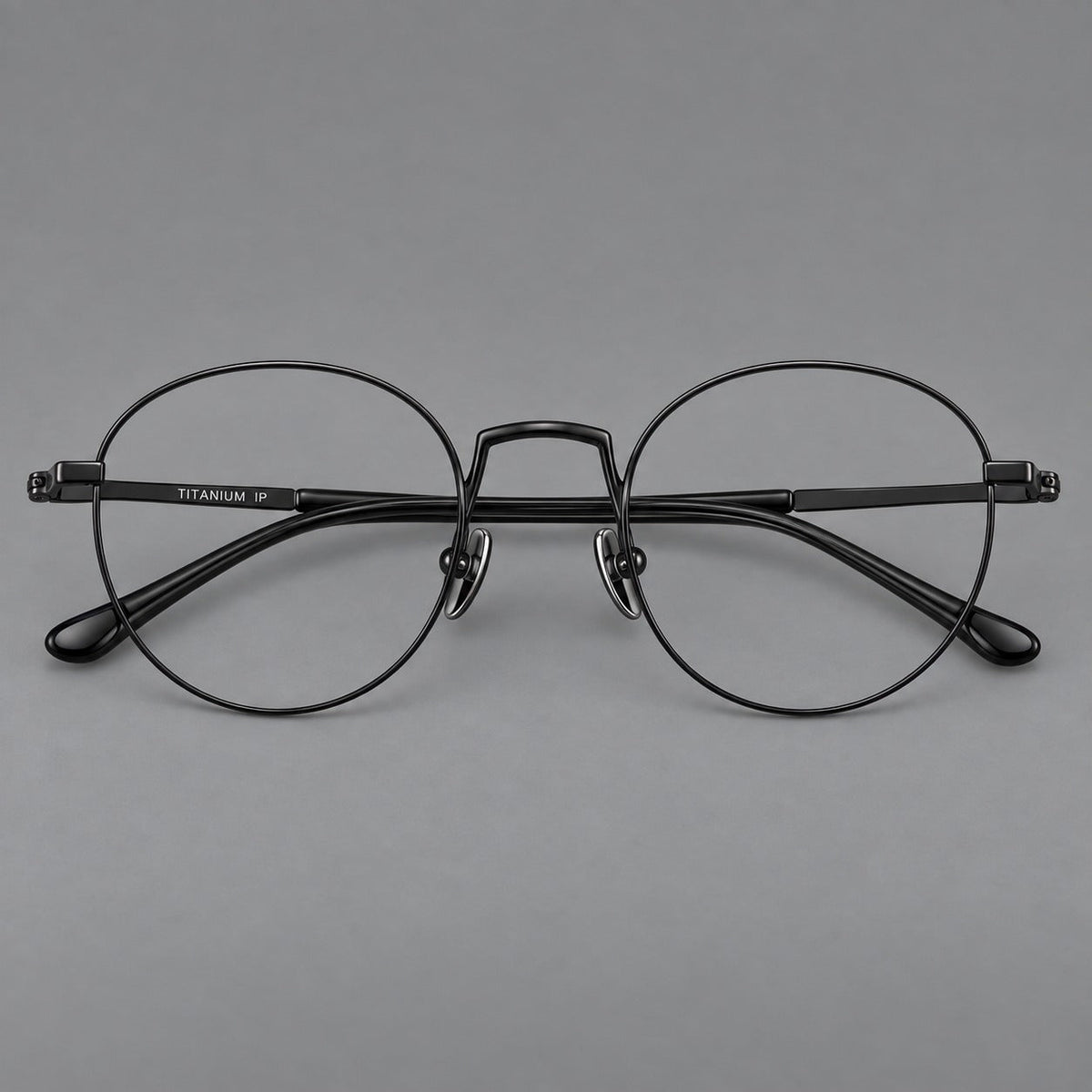 Retro round titanium glasses with a raised bridge and smooth corner shoulders in Black, front view