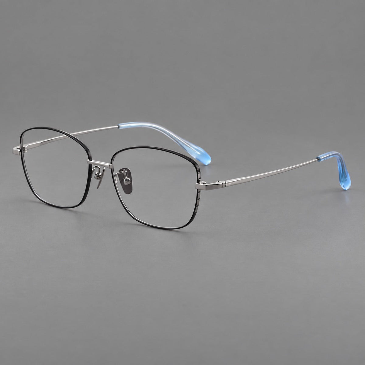 Soft square titanium glasses with angled upper corners and decorated hinges in Black and Silver, three quarter view