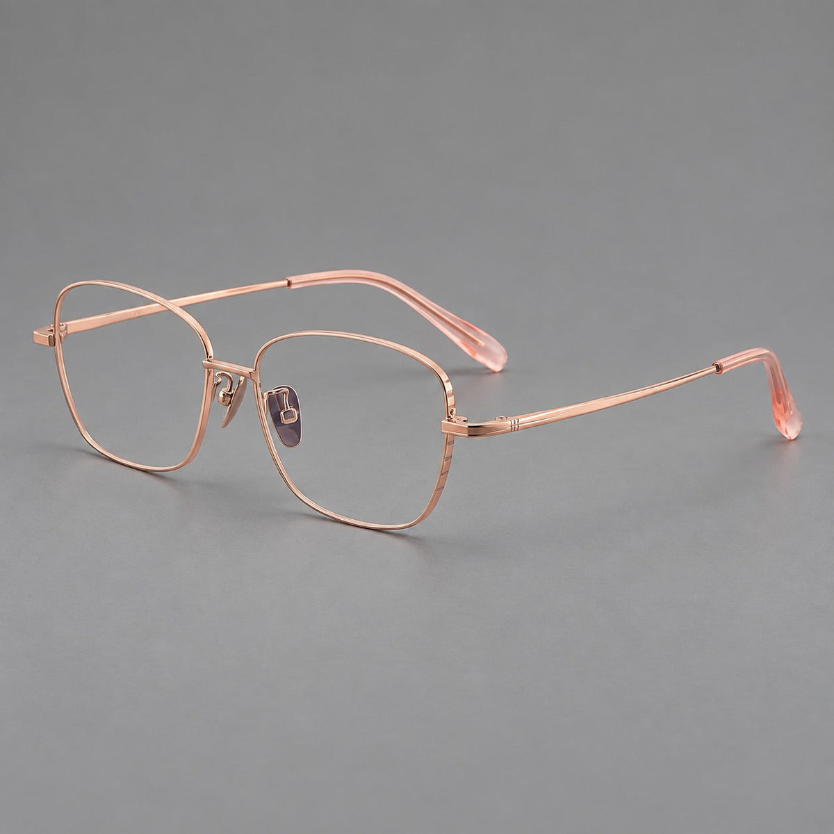 Soft square titanium glasses with angled upper corners and decorated hinges in Rose Gold, three quarter view