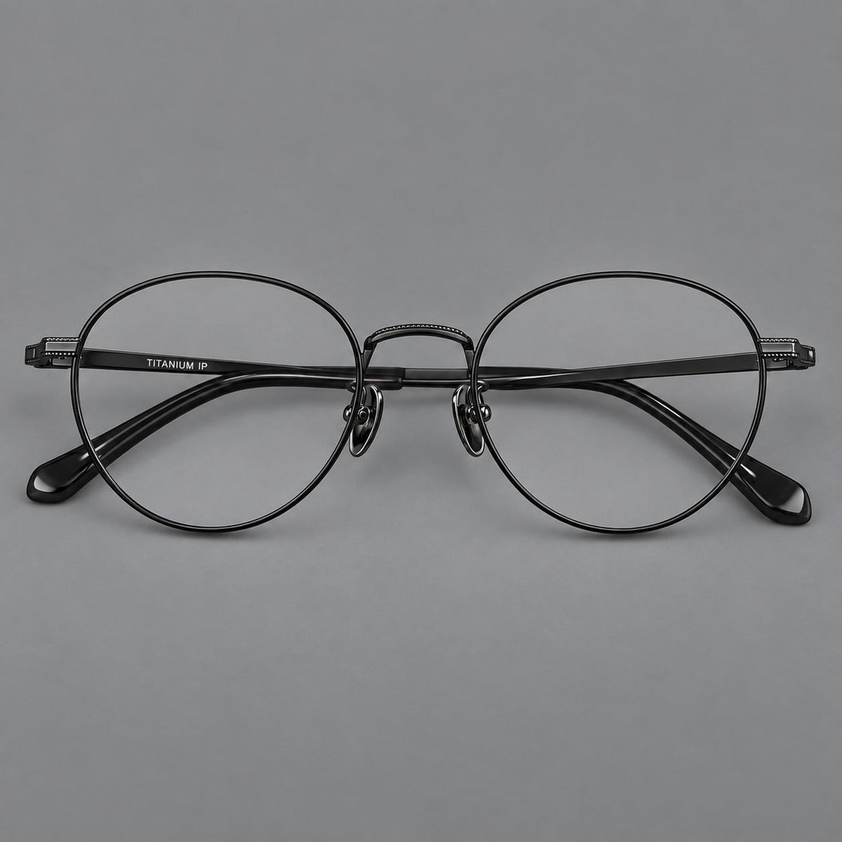 Rounded panto titanium glasses with a raised bridge and dotted temple accents in Black, front view