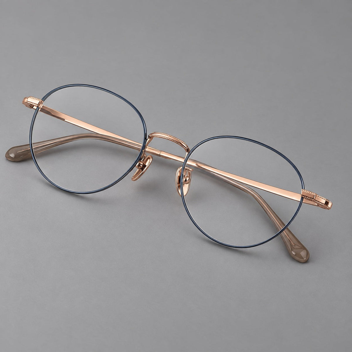 Rounded panto titanium glasses with a raised bridge and dotted temple accents in Blue and Rose Gold, three quarter view
