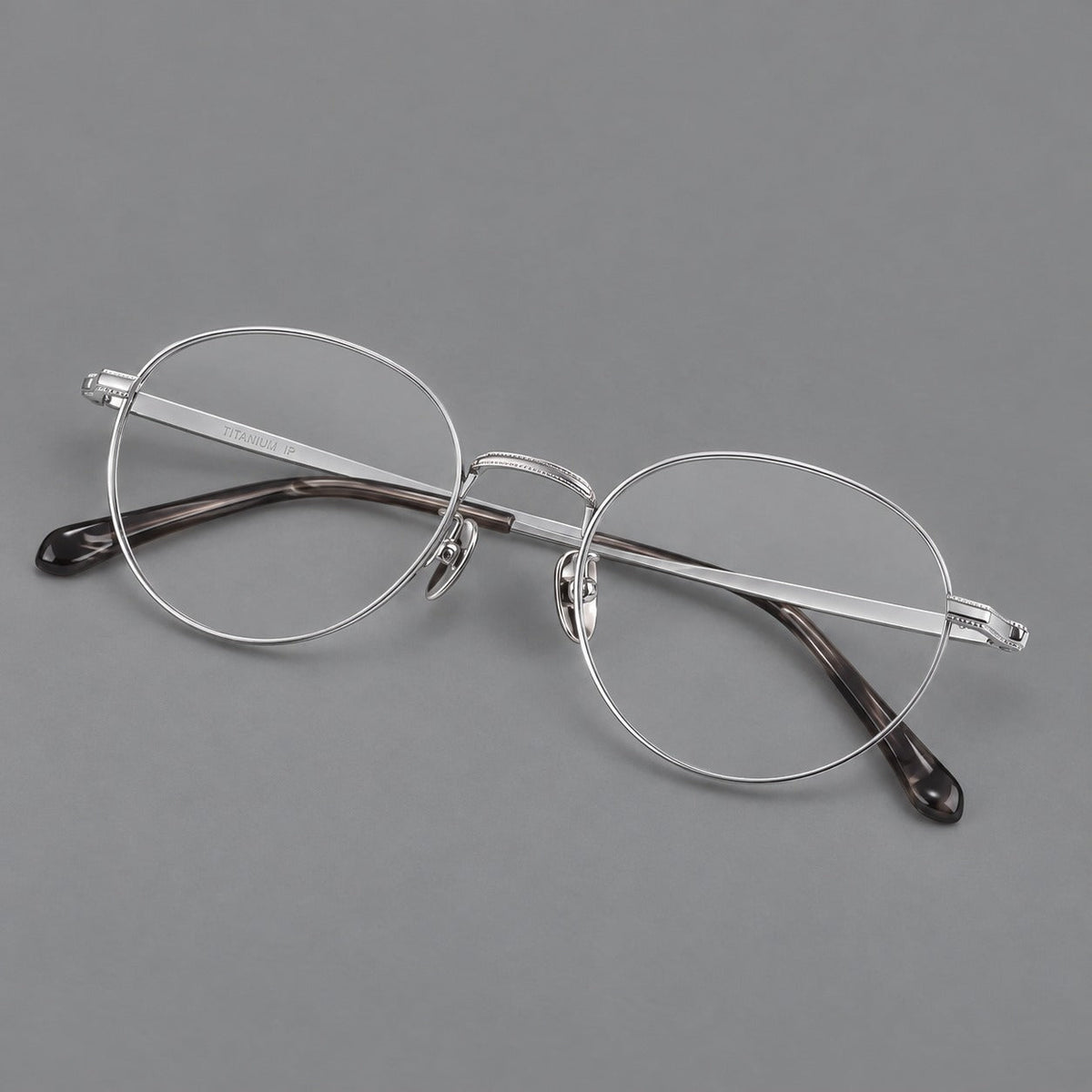 Rounded panto titanium glasses with a raised bridge and dotted temple accents in Silver, three quarter view
