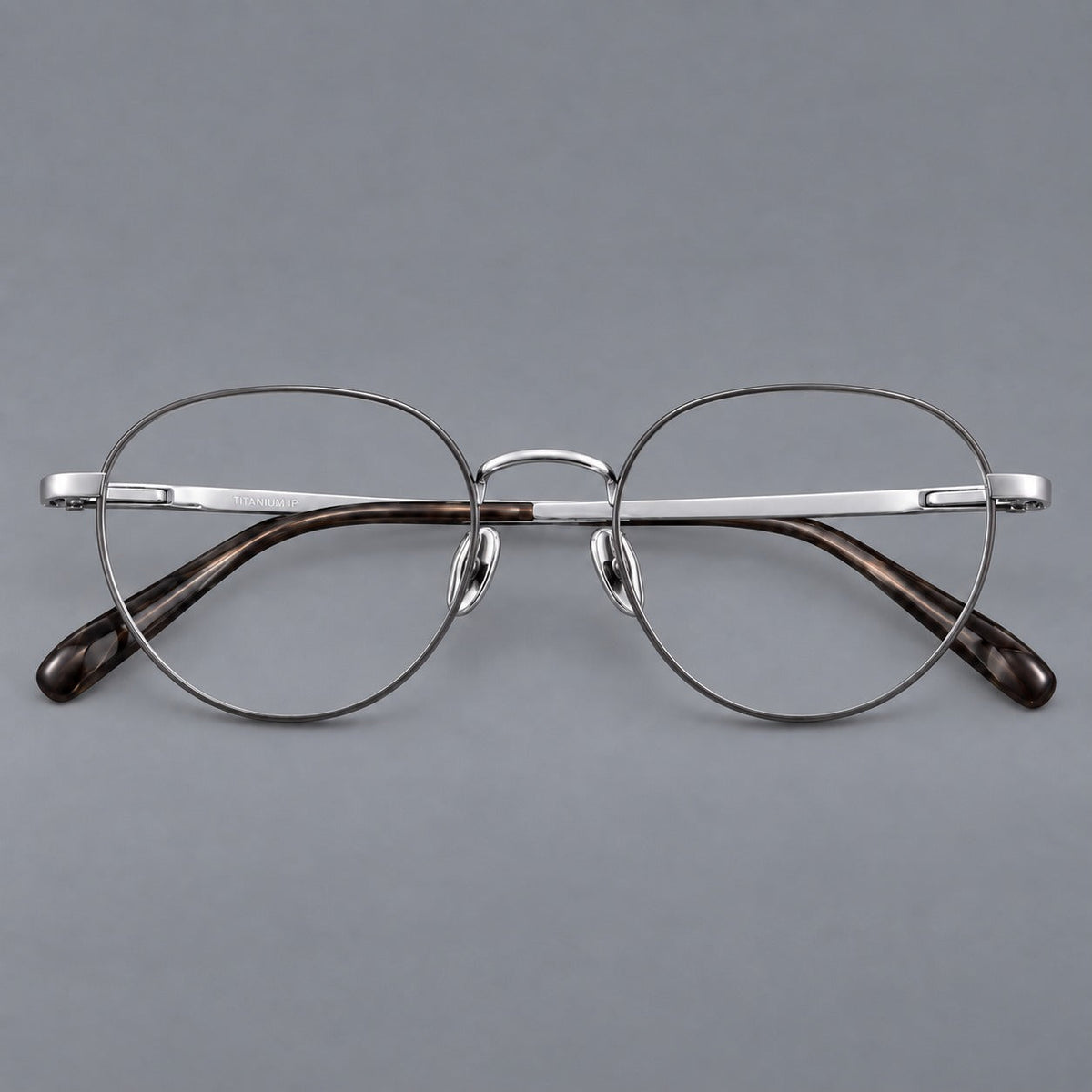 Classic round titanium glasses with broad flat temples and inset hinge details in Gray and Silver, front view