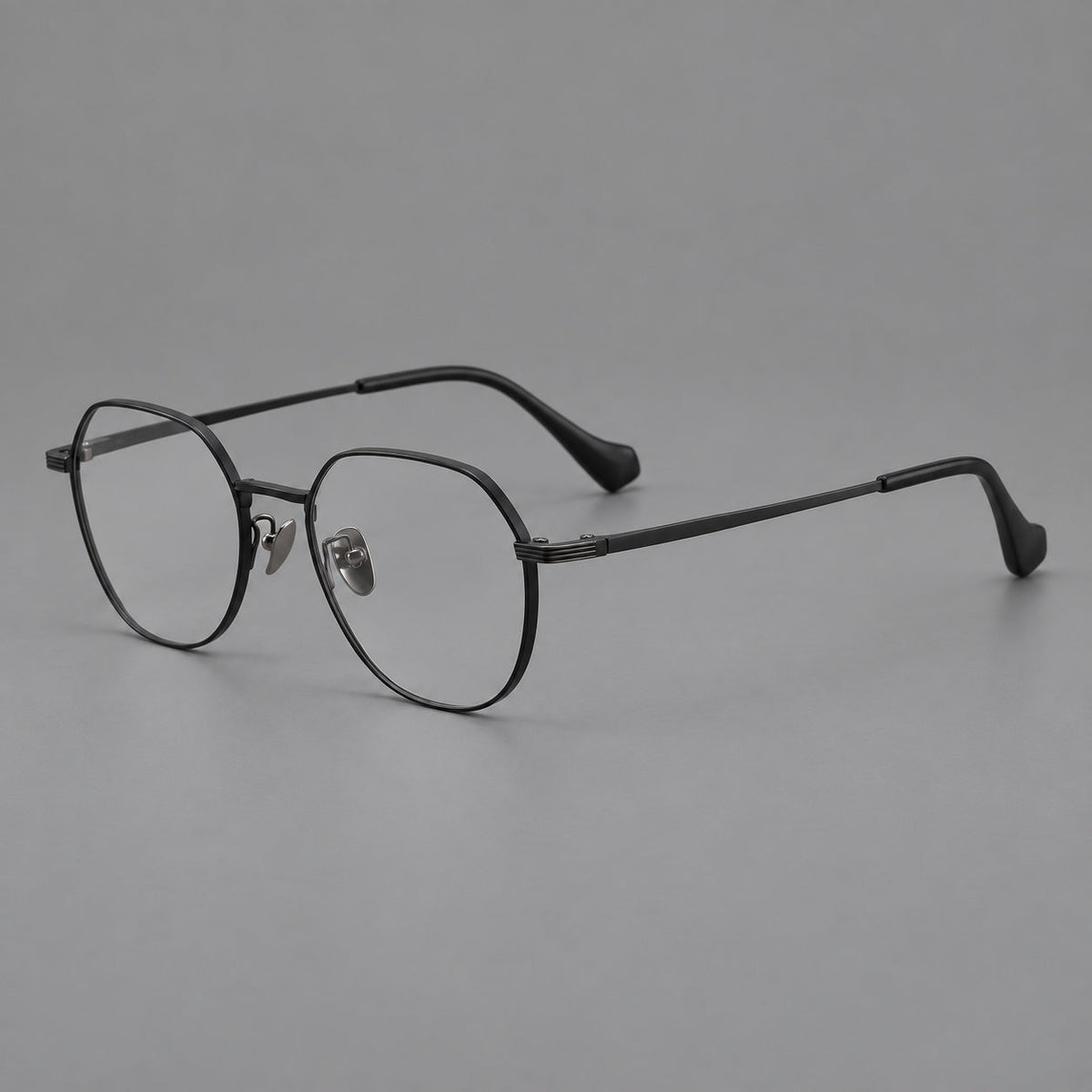 Geometric titanium glasses with soft polygonal rims and fine shoulder detailing in Black, three quarter view
