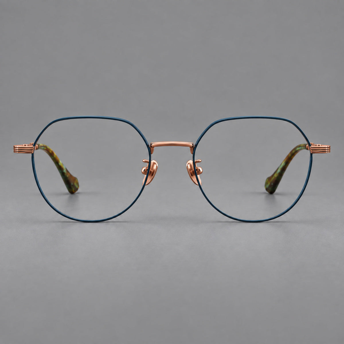 Geometric titanium glasses with soft polygonal rims and fine shoulder detailing in Blue and Rose Gold, front view