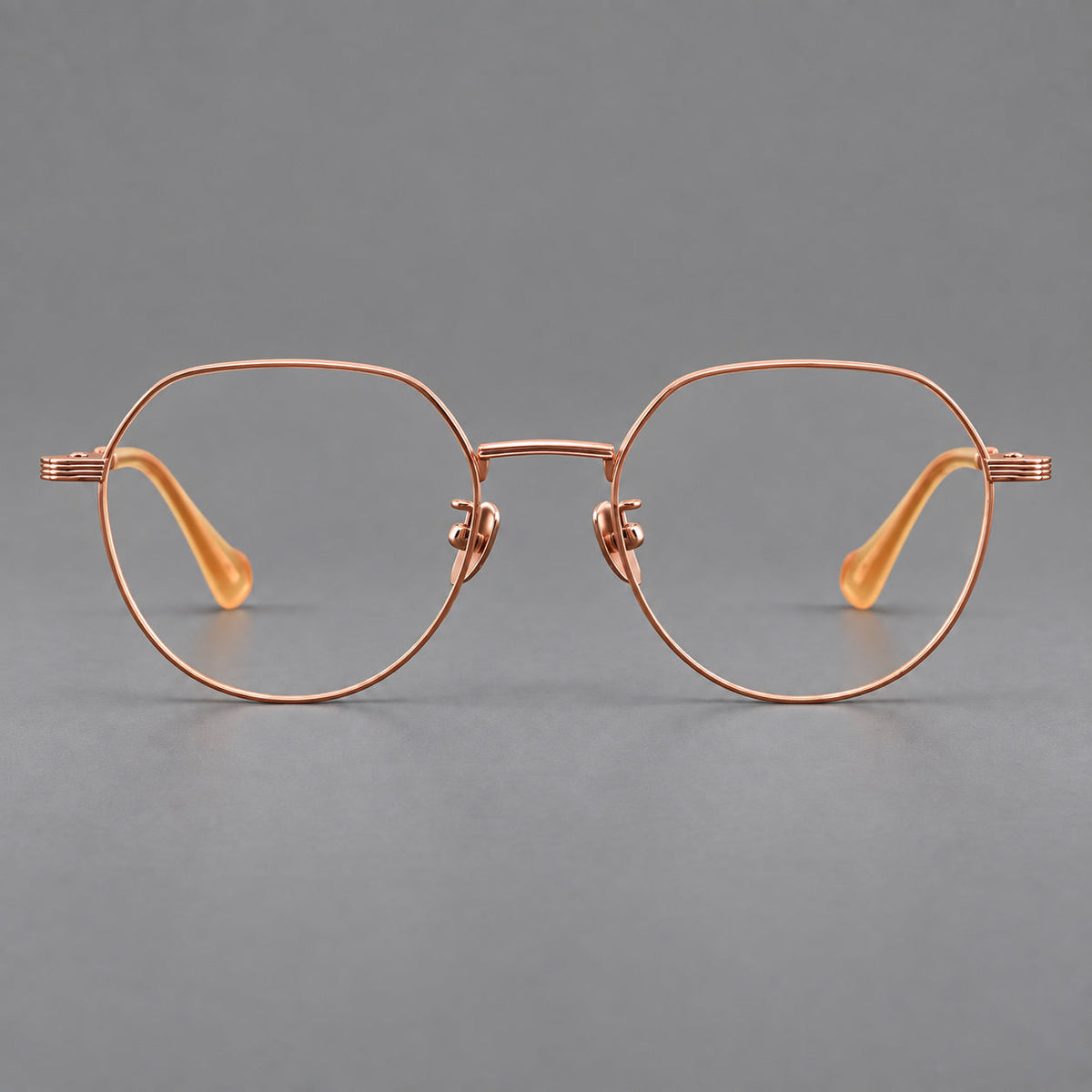 Geometric titanium glasses with soft polygonal rims and fine shoulder detailing in Rose Gold, front view
