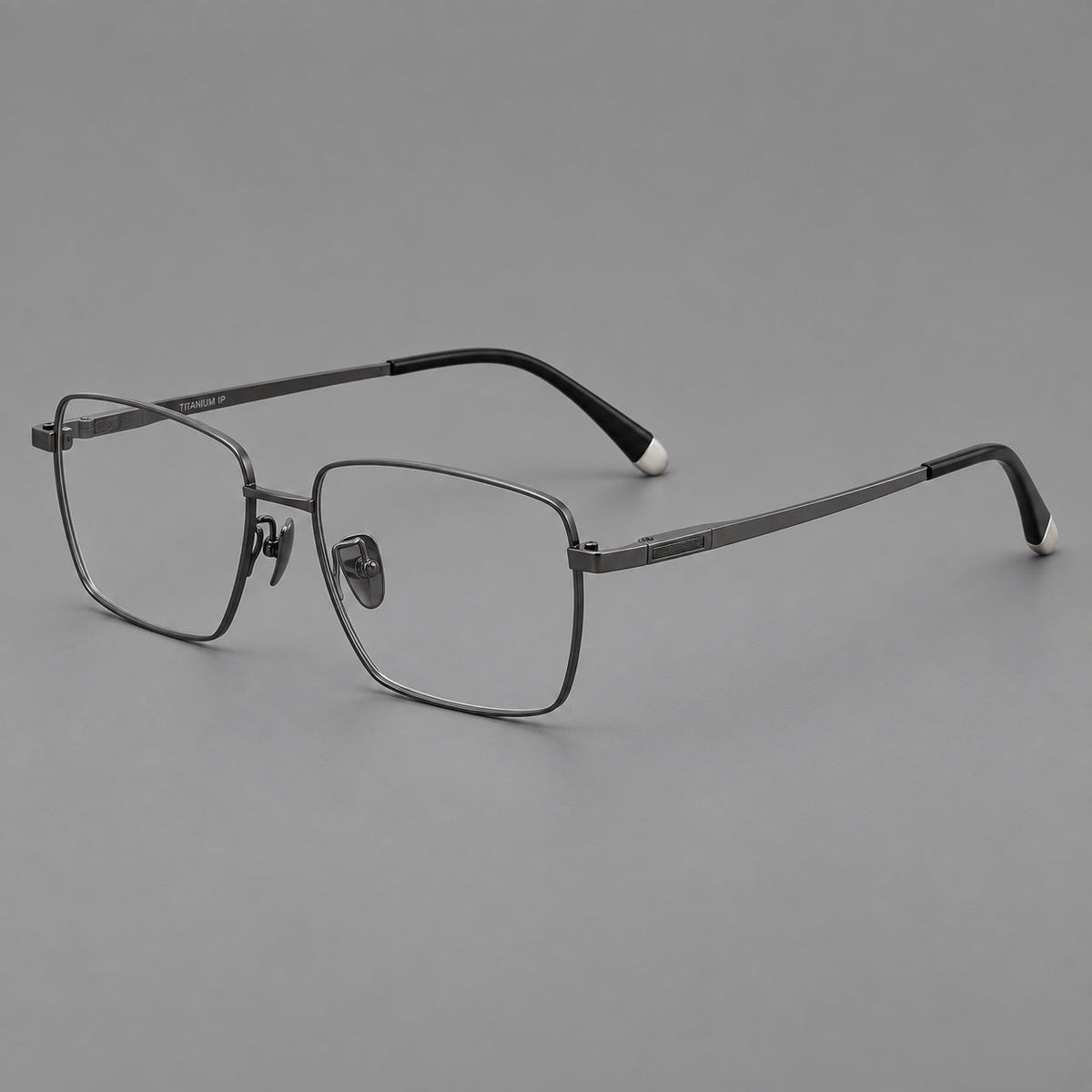 Clean rectangular titanium glasses with inset temple details and pale end accents in Gunmetal, three quarter view