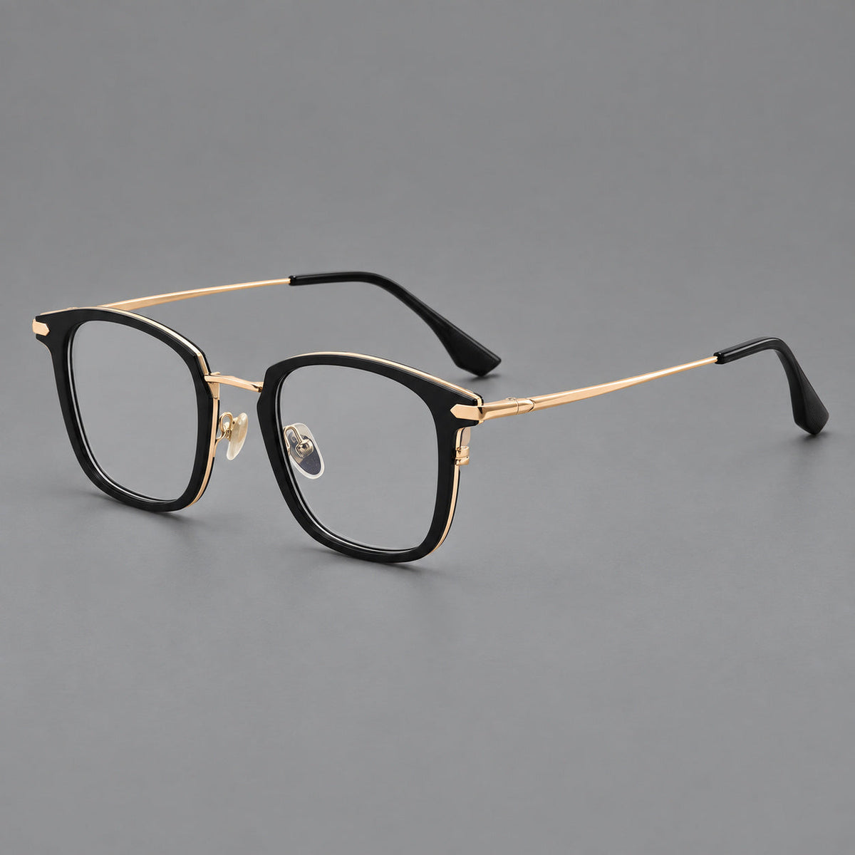 Bold square titanium glasses with a separate bridge and long metal corner accents in Black and Gold, three quarter view