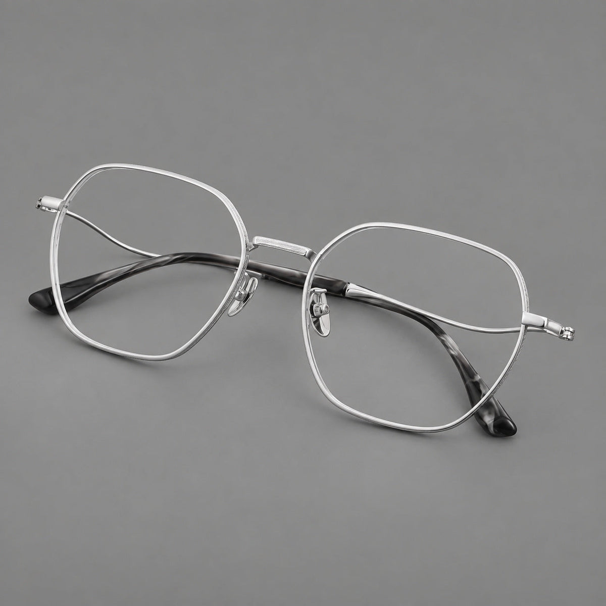 Geometric titanium glasses with engraved rim edges and curved temple joins in Silver, three quarter view