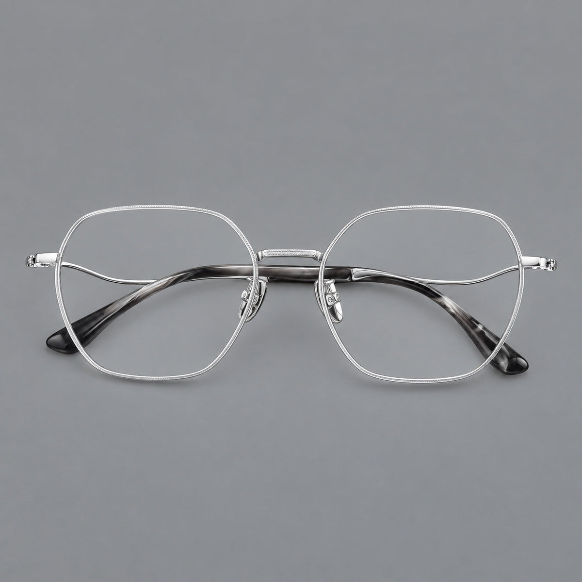 Geometric titanium glasses with engraved rim edges and curved temple joins in Silver, front view