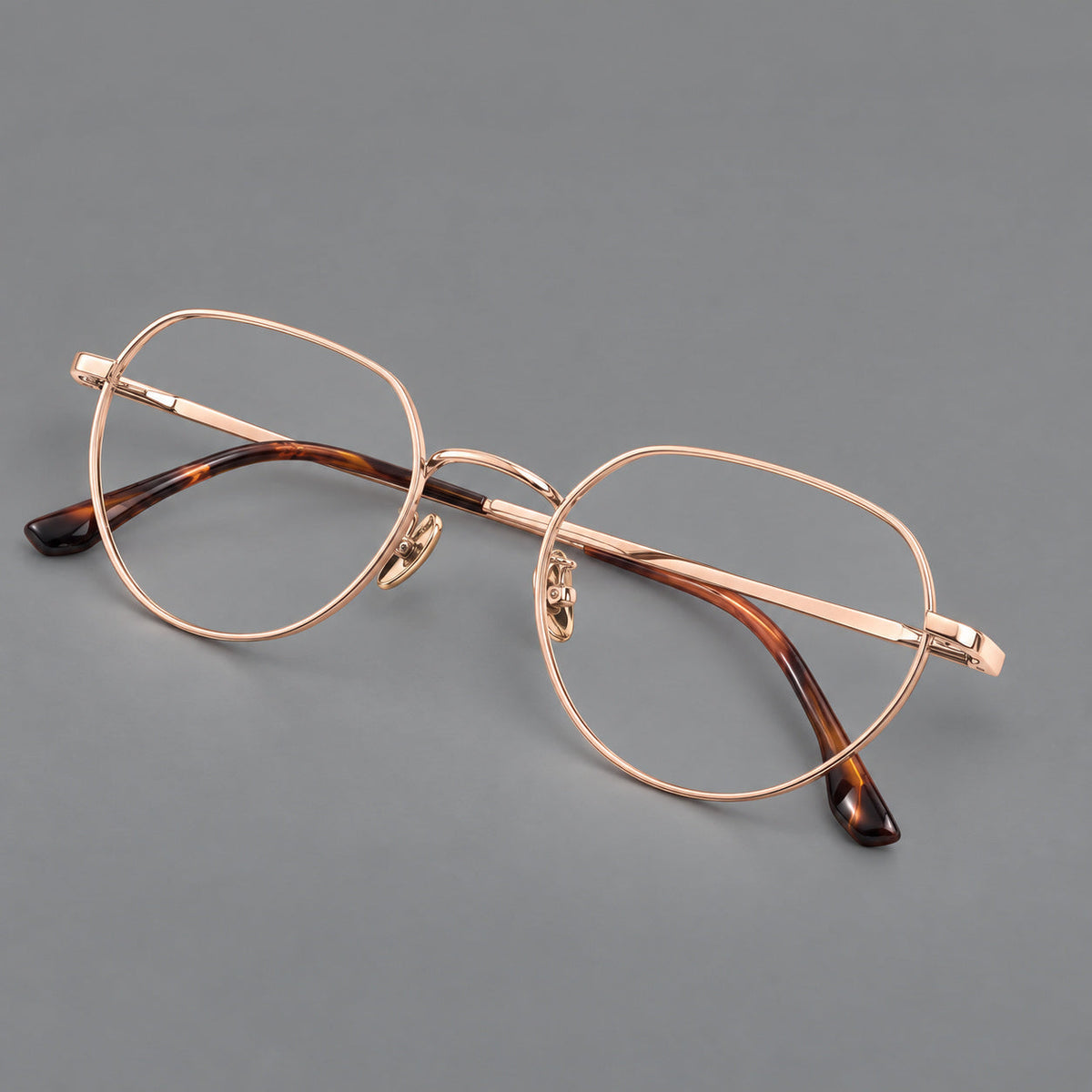Classic panto titanium glasses with a curved bridge and slim straight temples in Rose Gold, three quarter view