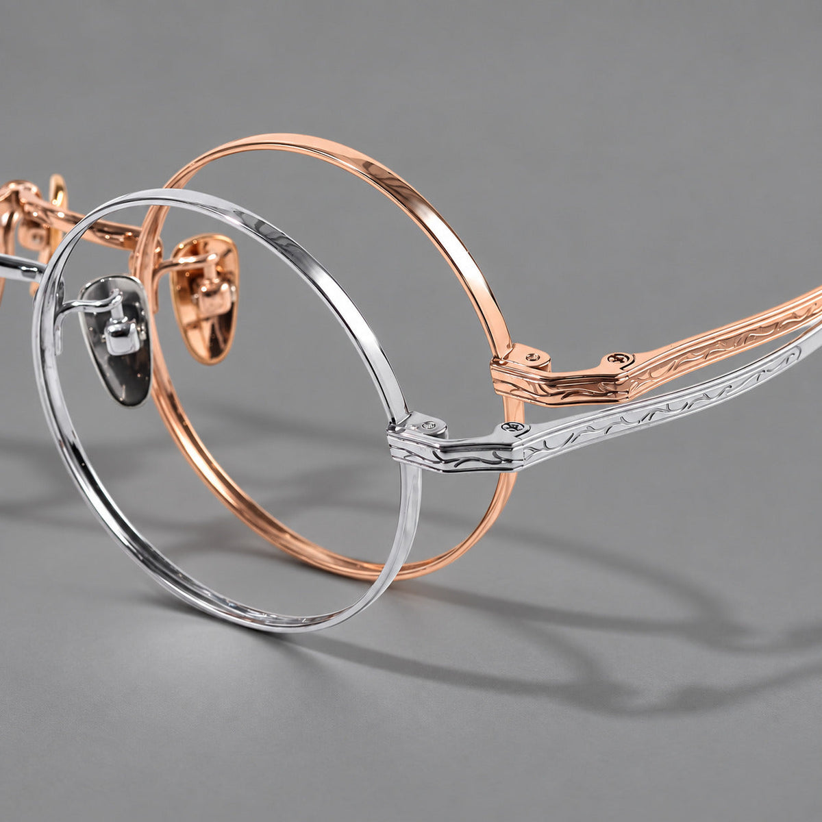 Compact circular titanium glasses with a curved bridge and wavy engraved temples, frame details