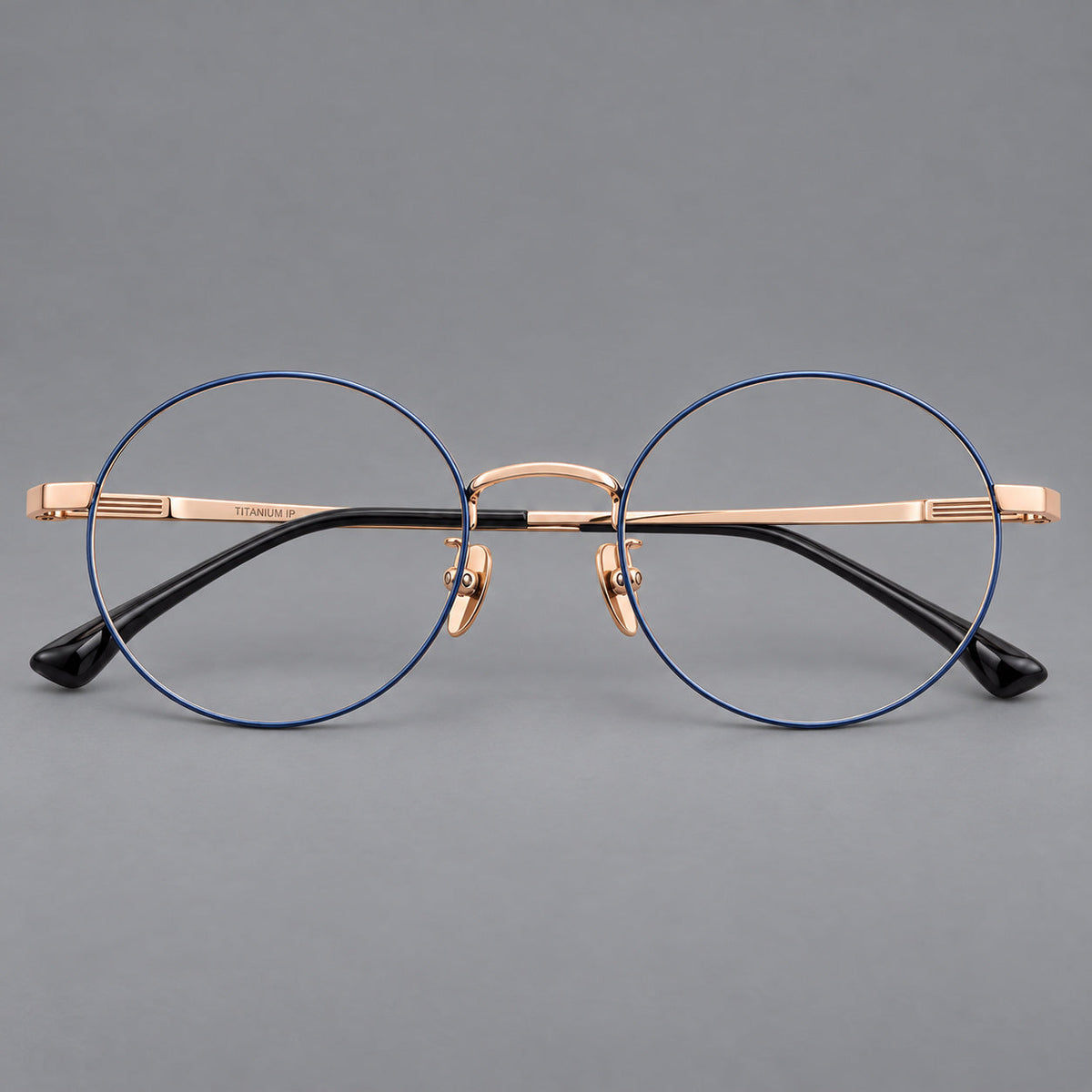 Classic circular titanium glasses with a raised bridge and lined temple accents in Blue and Gold, front view