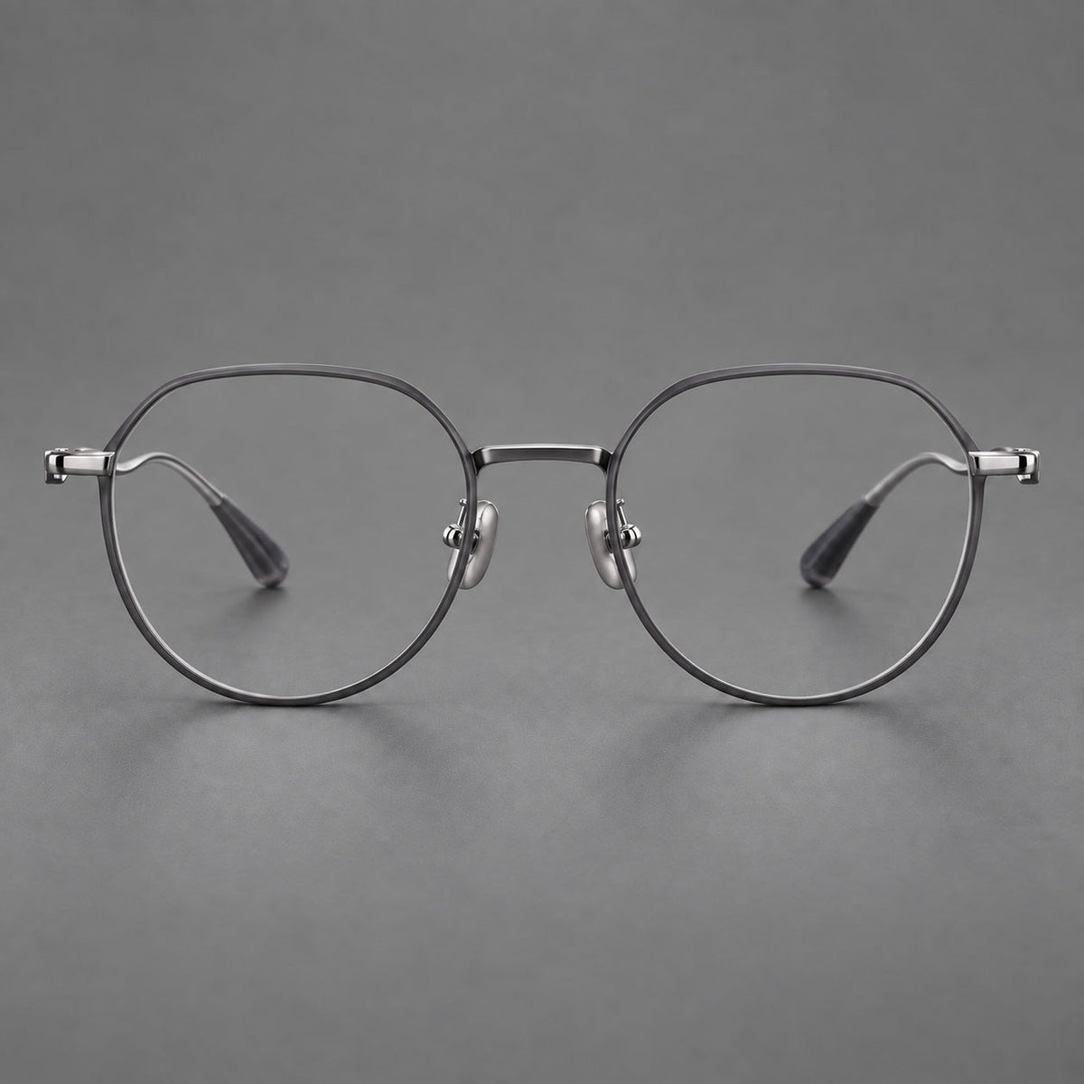 Rounded titanium glasses with a short bridge and distinctive wavy metal temples in Matte Gray and Silver, front view