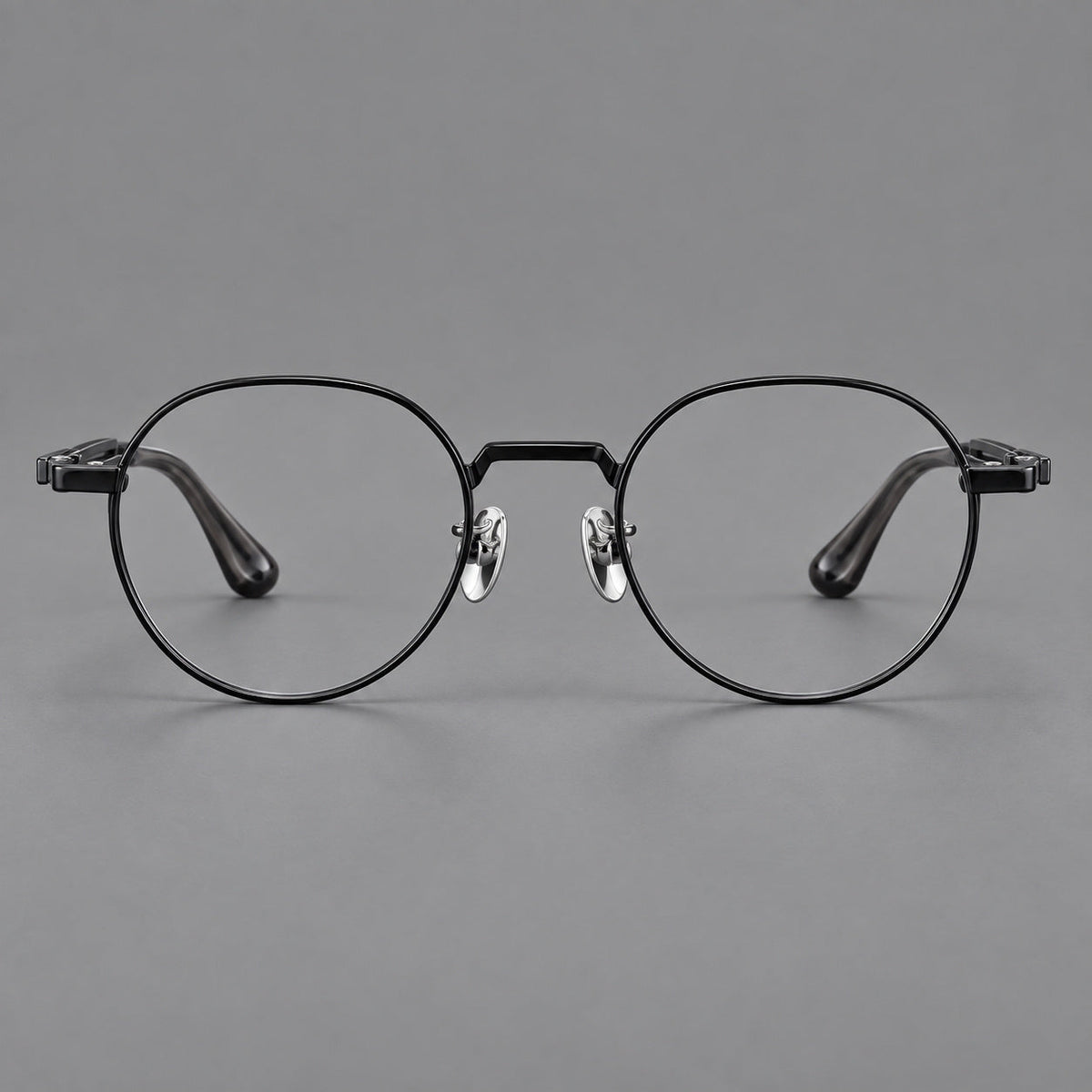 Small panto titanium glasses with an angular bridge and recessed temple details in Black, front view