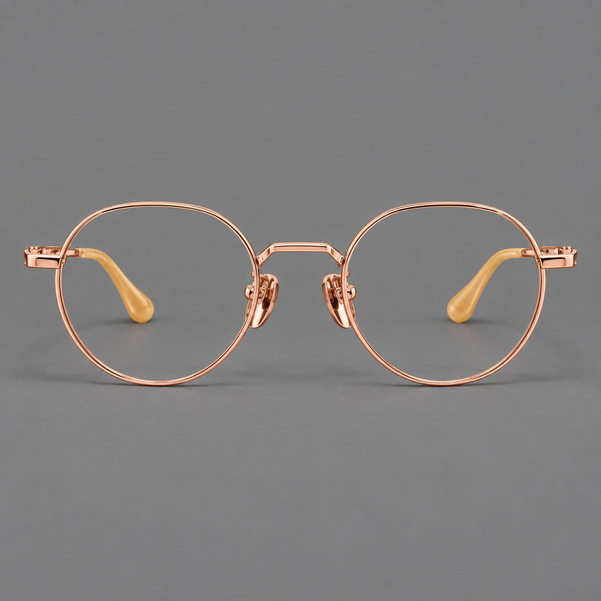 Small panto titanium glasses with an angular bridge and recessed temple details in Rose Gold, front view