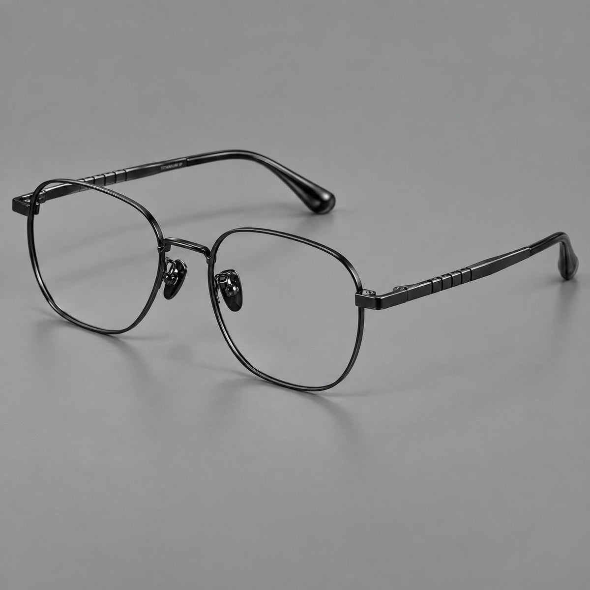 Soft square titanium glasses with a raised bridge and engraved temple bands in Black, three quarter view