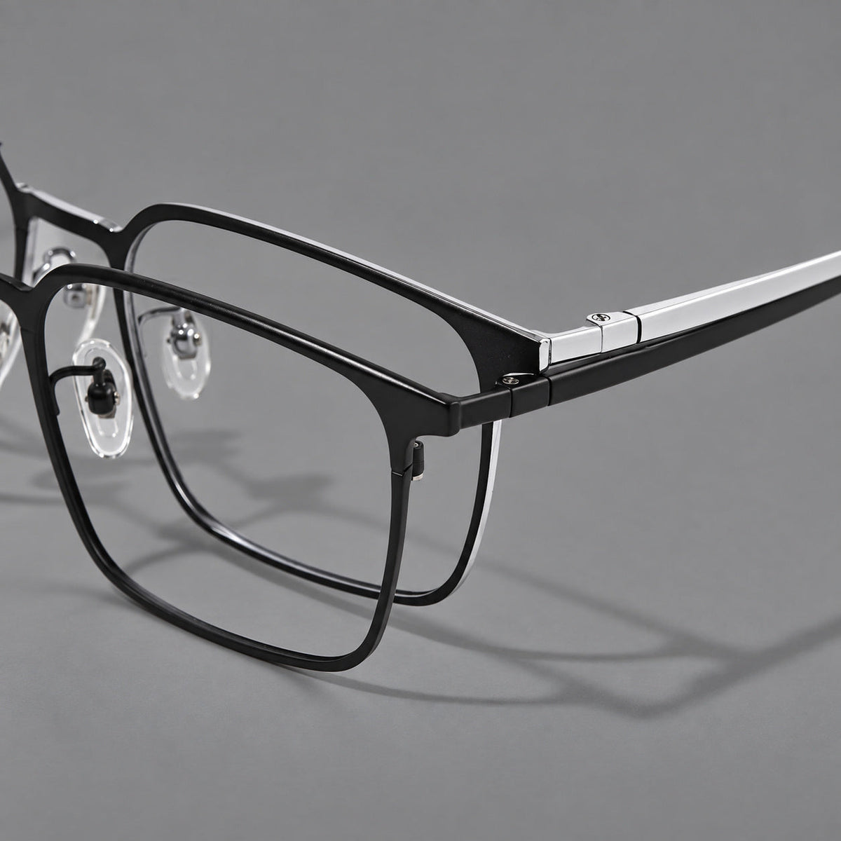 Bold rectangular titanium glasses with strong upper corners and flat metal temples, frame details