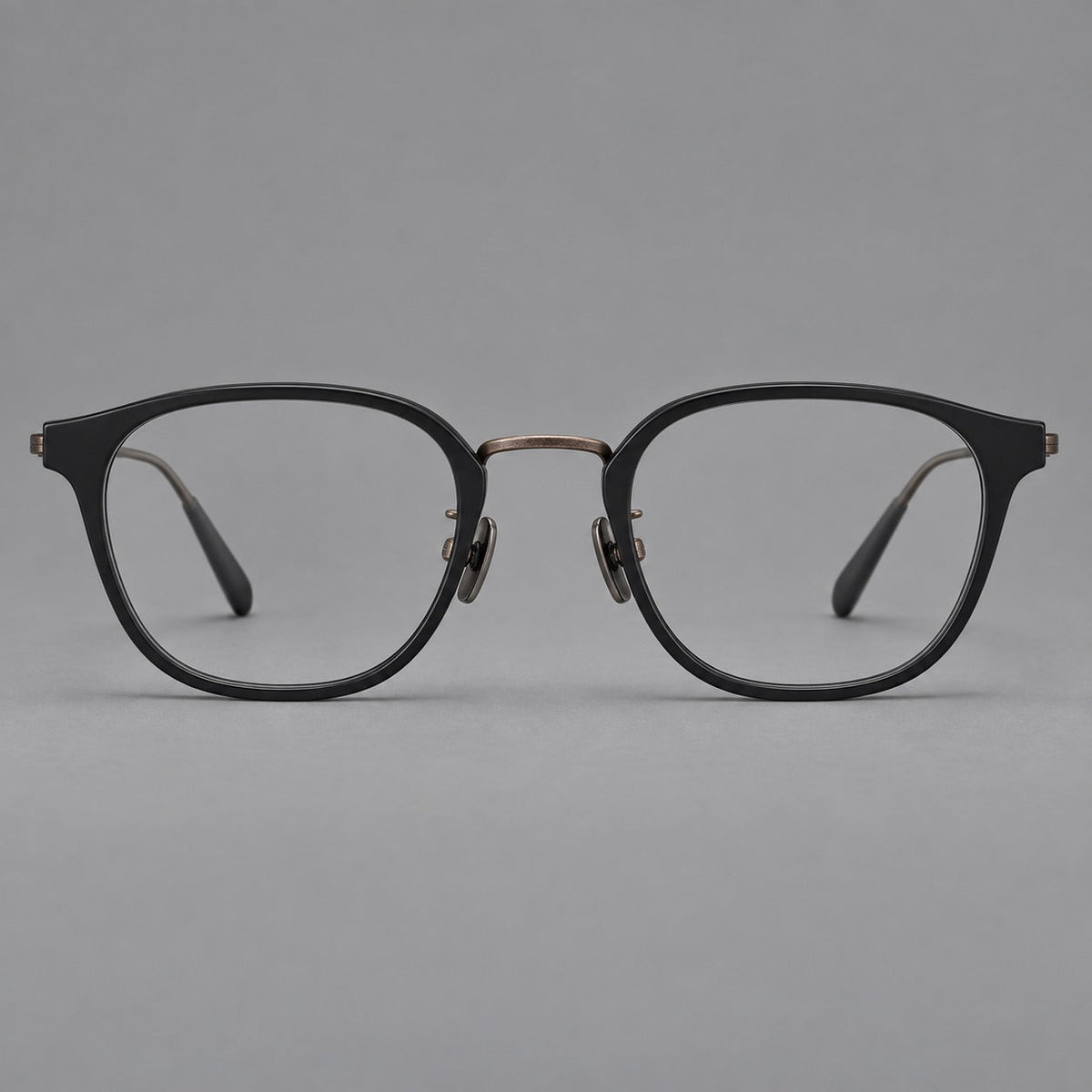 Retro soft square eyeglasses in acetate and titanium with a curved bridge and slender temples in Matte Black / Antique Copper, front view
