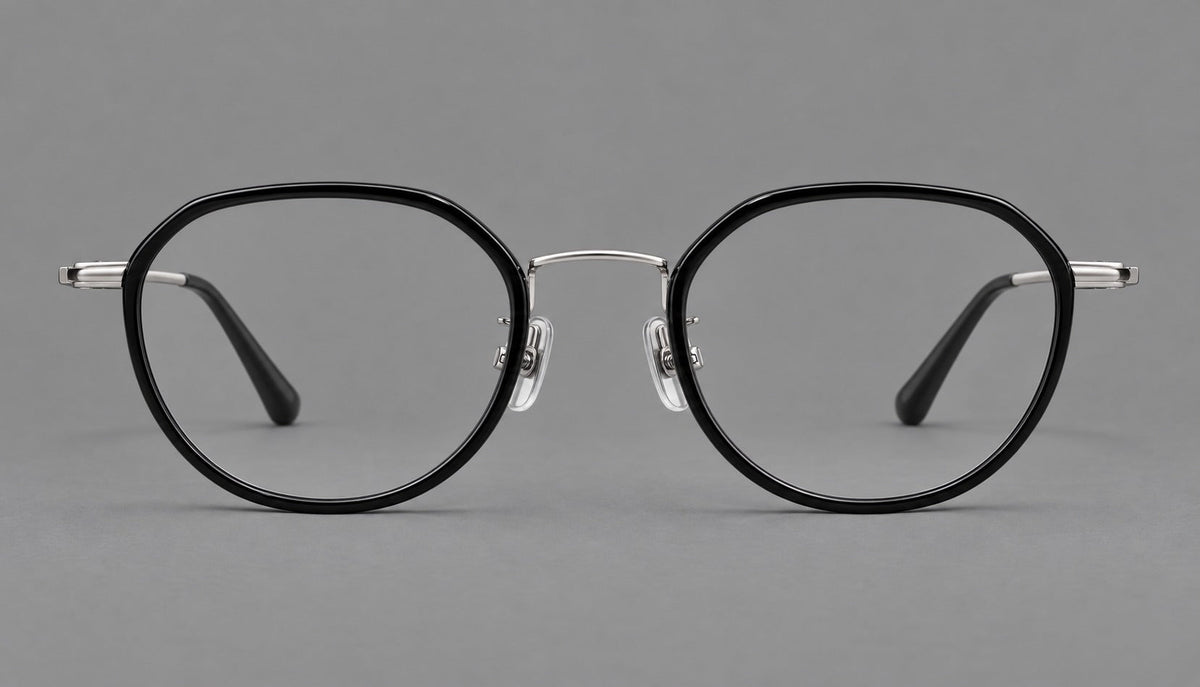 Rounded eyeglasses in acetate and titanium with gently arched brows and engraved metal temples in Black / Silver, front view