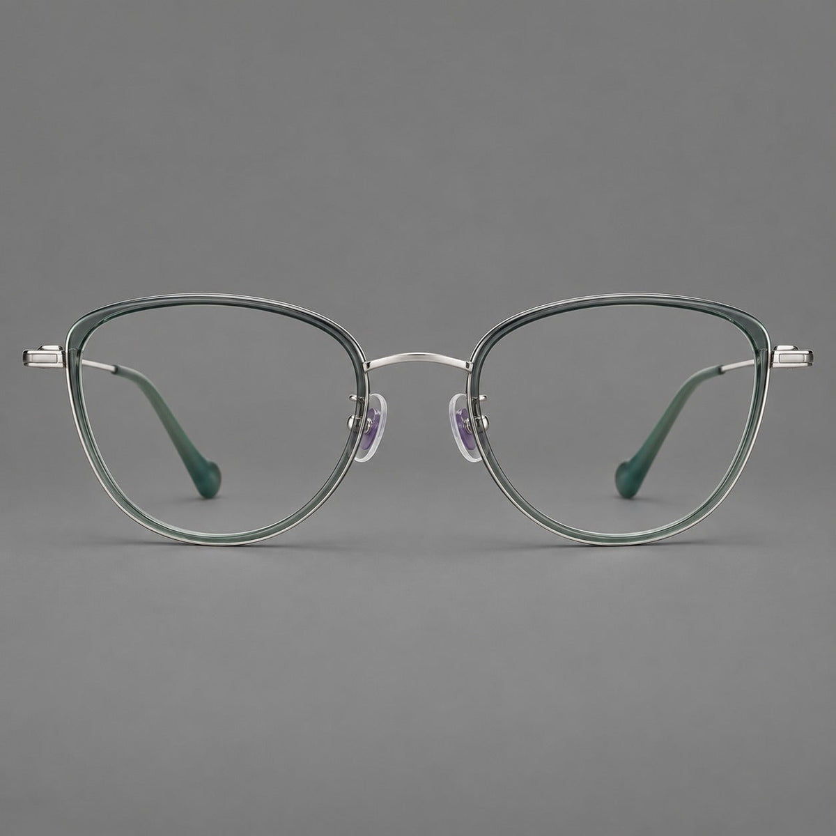 Upswept eyeglasses in acetate and titanium with softly rounded rims and tapered metal temples in Clear Green / Silver, front view