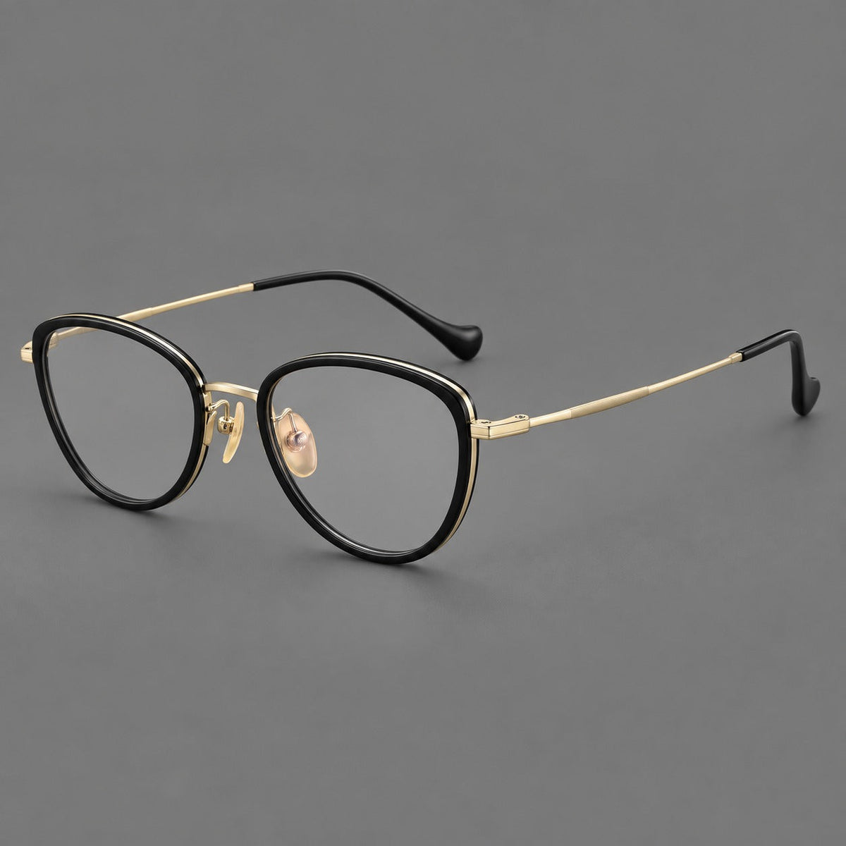Upswept eyeglasses in acetate and titanium with softly rounded rims and tapered metal temples in Black / Gold, three quarter view