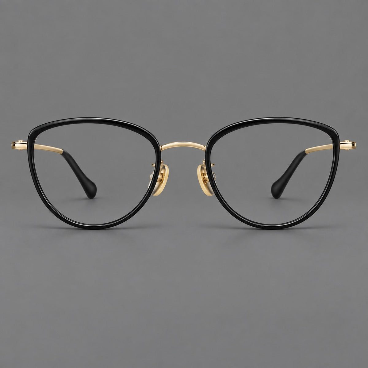 Upswept eyeglasses in acetate and titanium with softly rounded rims and tapered metal temples in Black / Gold, front view