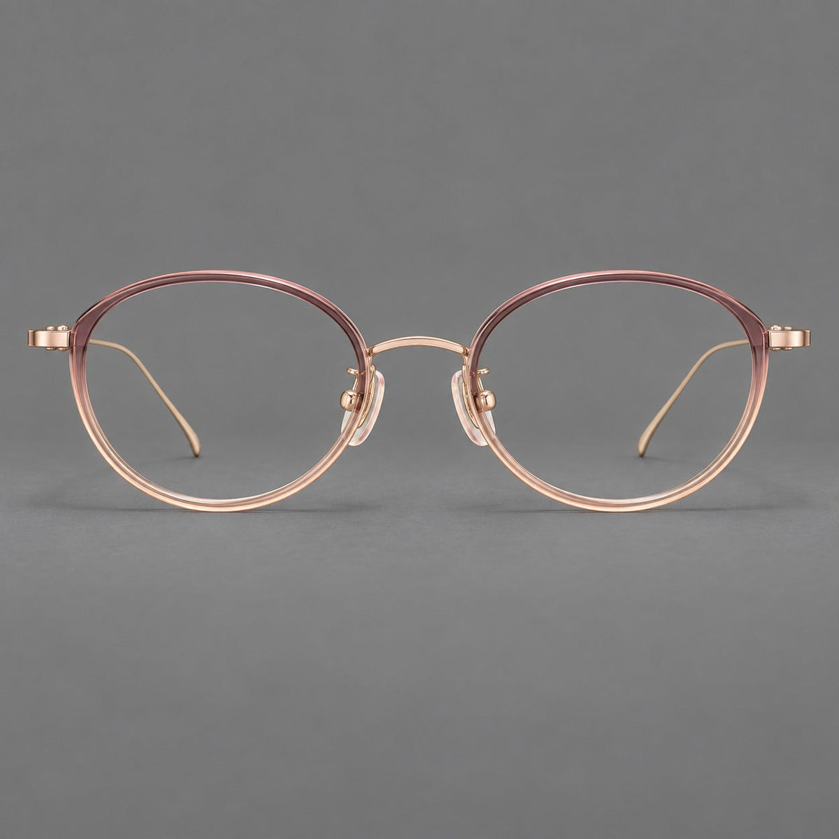 Round eyeglasses in acetate and titanium with a slim curved bridge and fine metal temples in Pink Tea Gradient / Rose Gold, front view