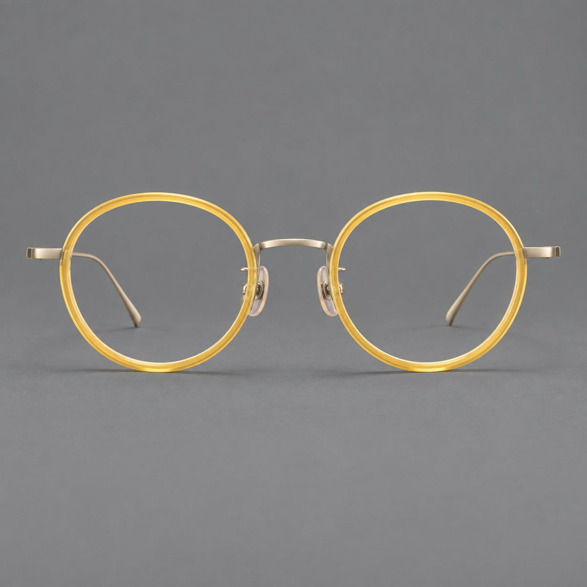 Classic round eyeglasses in acetate and titanium with slim rims and textured metal temples in Lemon Yellow / Gold, front view