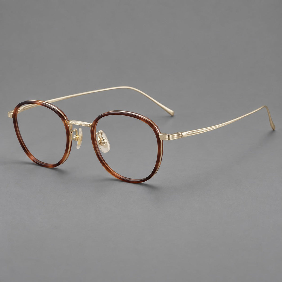 Vintage round eyeglasses in acetate and titanium with an engraved bridge and slender temples in Tortoiseshell / Light Gold, three quarter view