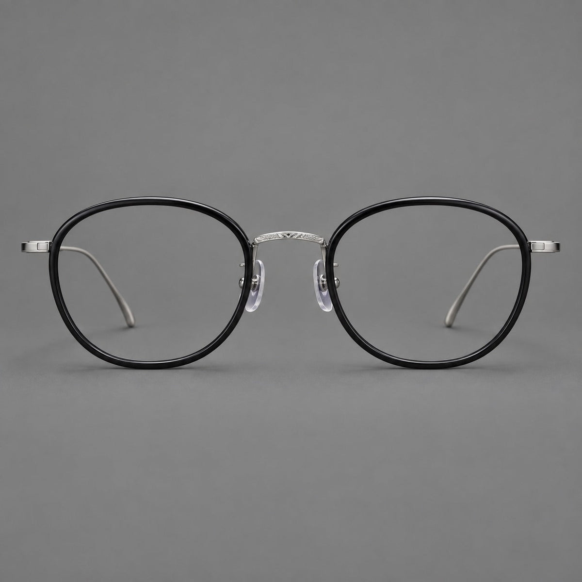 Vintage round eyeglasses in acetate and titanium with an engraved bridge and slender temples in Glossy Black / Gunmetal, front view
