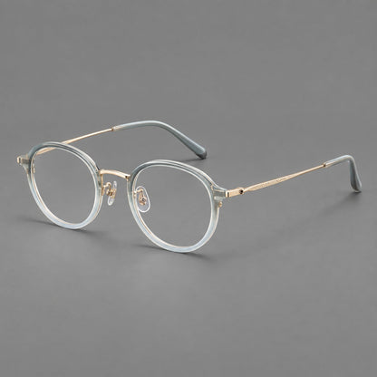 Softly rounded eyeglasses in acetate and titanium with a curved bridge and engraved temples in Ice Blue Gray / Gold, three quarter view