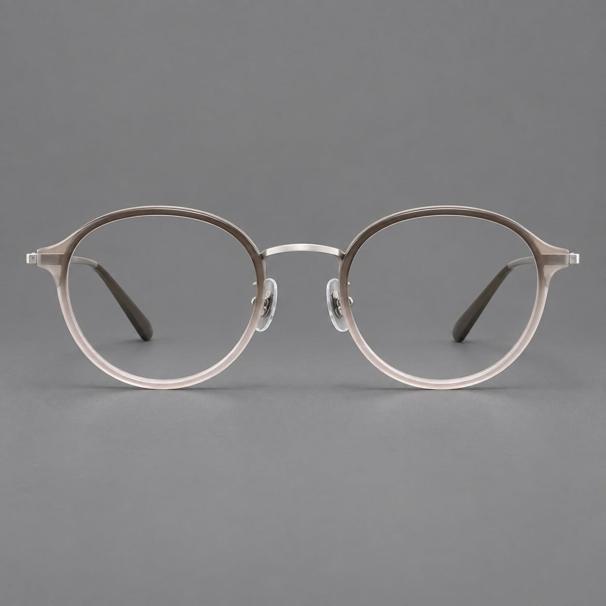 Softly rounded eyeglasses in acetate and titanium with a curved bridge and engraved temples in Tea Pink Gradient / Silver, front view