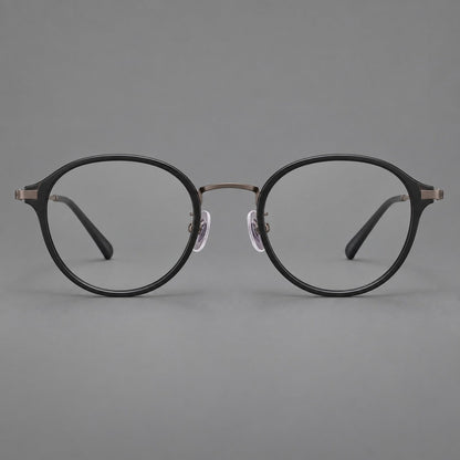 Softly rounded eyeglasses in acetate and titanium with a curved bridge and engraved temples in Matte Black / Antique Copper, front view additional product view